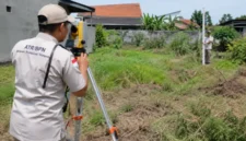 Petugas melakukan pengukuran bidang tanah sebagai bagian dari layanan Pengukuran Terjadwal untuk pendaftaran tanah pertama kali (Ilustrasi AI: sisipublik.com))