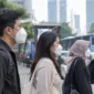 Warga mengenakan masker untuk mengurangi risiko paparan abu vulkanik Anak Krakatau yang menyebar ke sejumlah wilayah di Pulau Jawa (Ilustrasi AI : sisipublik.com)