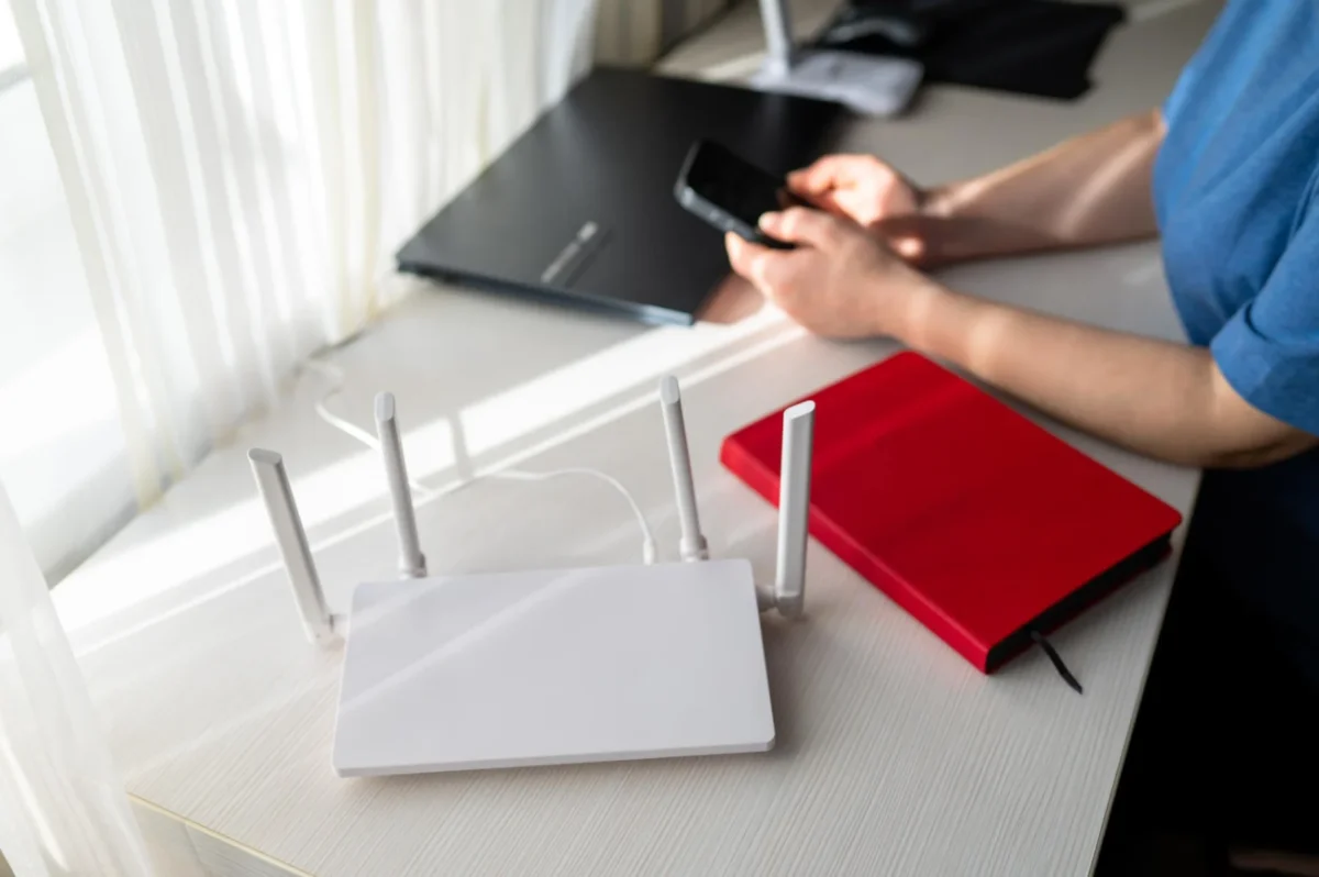 Pengguna dapat memeriksa daftar perangkat melalui pengaturan router di HP untuk mengenali koneksi yang tidak dikenal dan memperkuat keamanan WiFi rumah (Ilustrasi AI: sisipublik.com)
